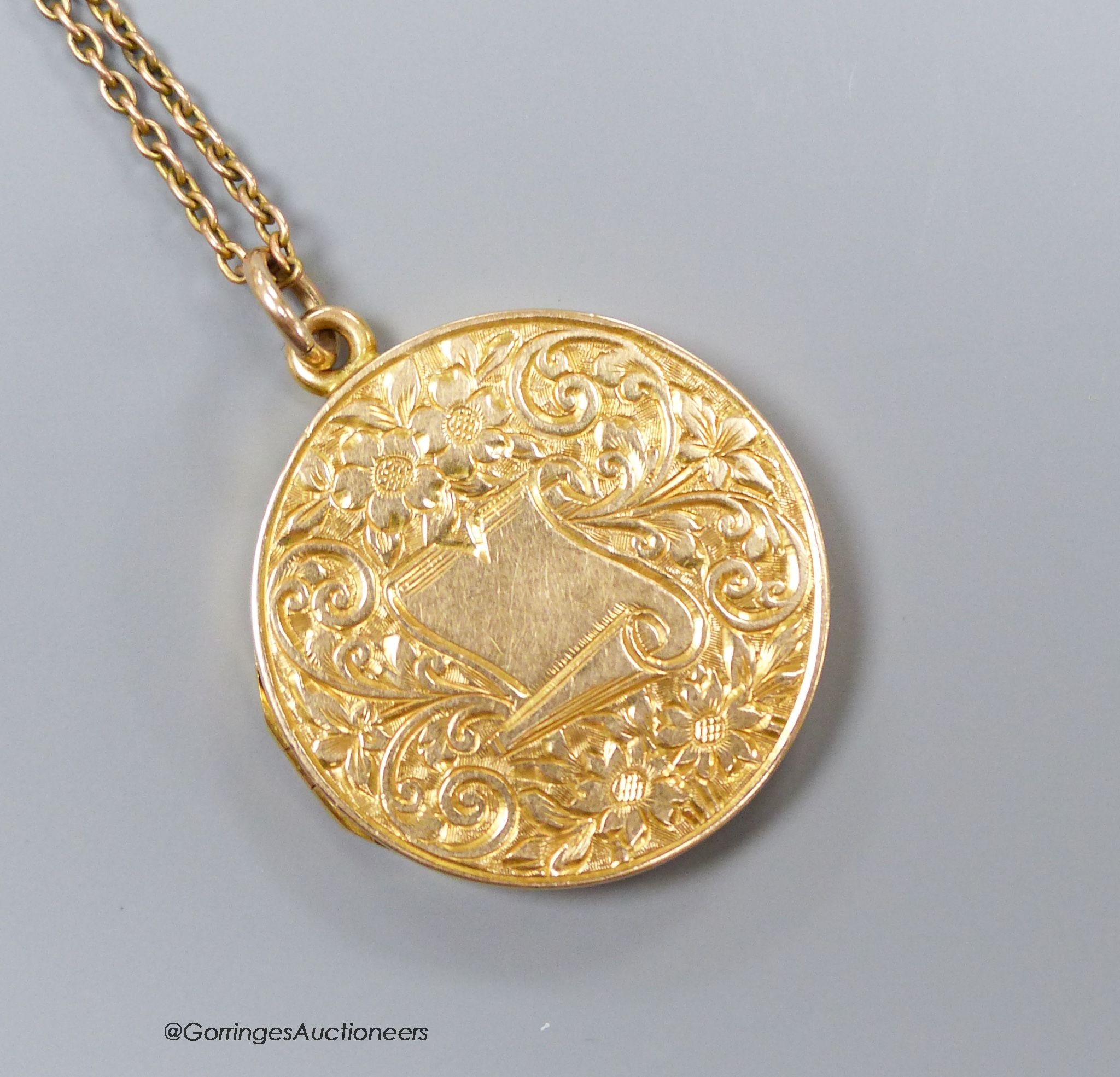 A 15ct engraved gold locket on a fine 9ct gold chain, 8.6g, 2.5cm.